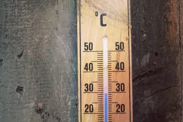 An old thermometer on a wooden wall