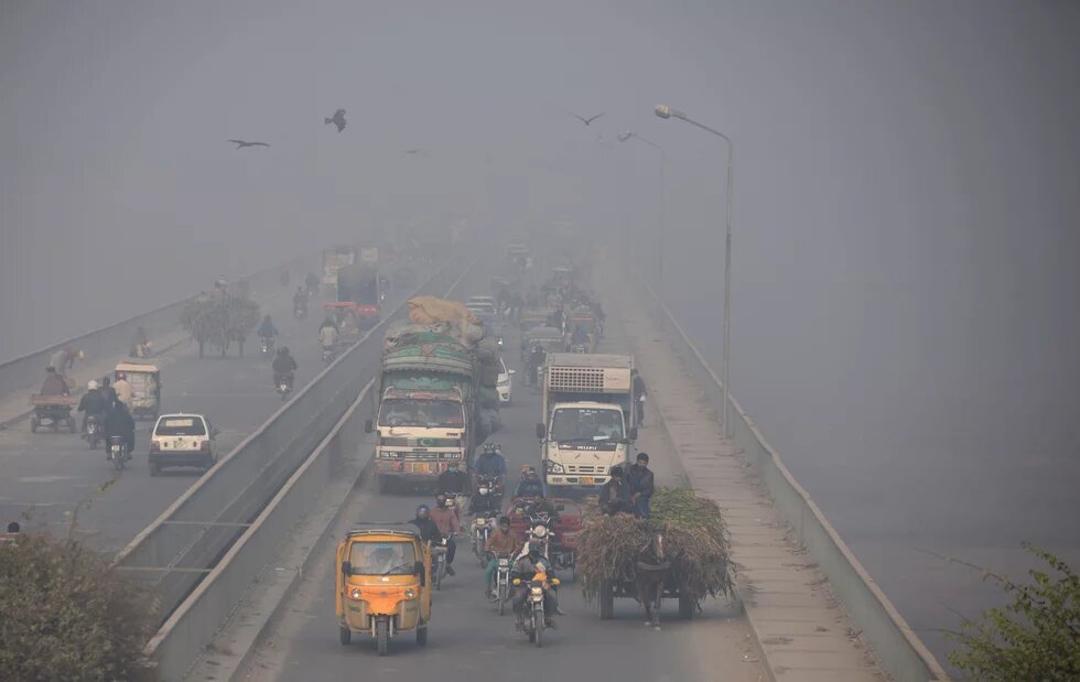 Street photo of people commuting amid smoggy conditions in Lahore, Pakistan on December 2, 2021
